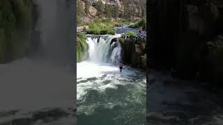 Cliff jumping into a waterfall near Bend,...